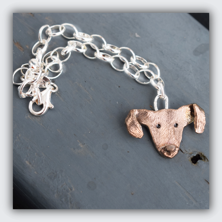 a silver and rose gold dog head charm custom made to look like customer dog photos